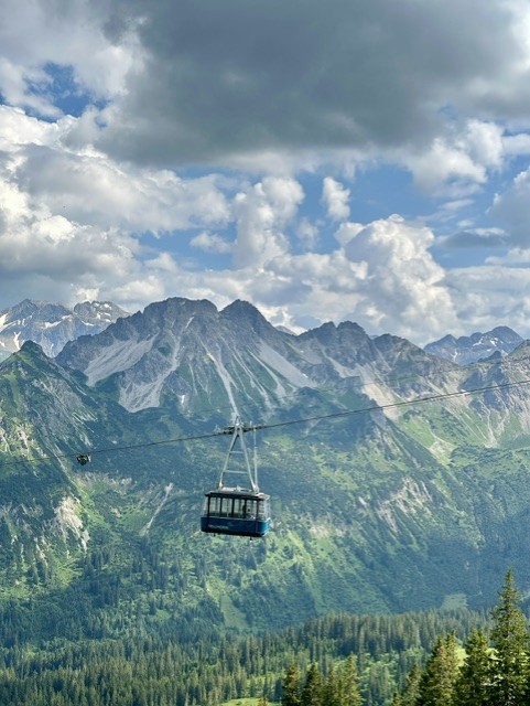 Bergbahn vor beeindruckendem Bergpanorama mit gr&uuml;nen Bergwiesen